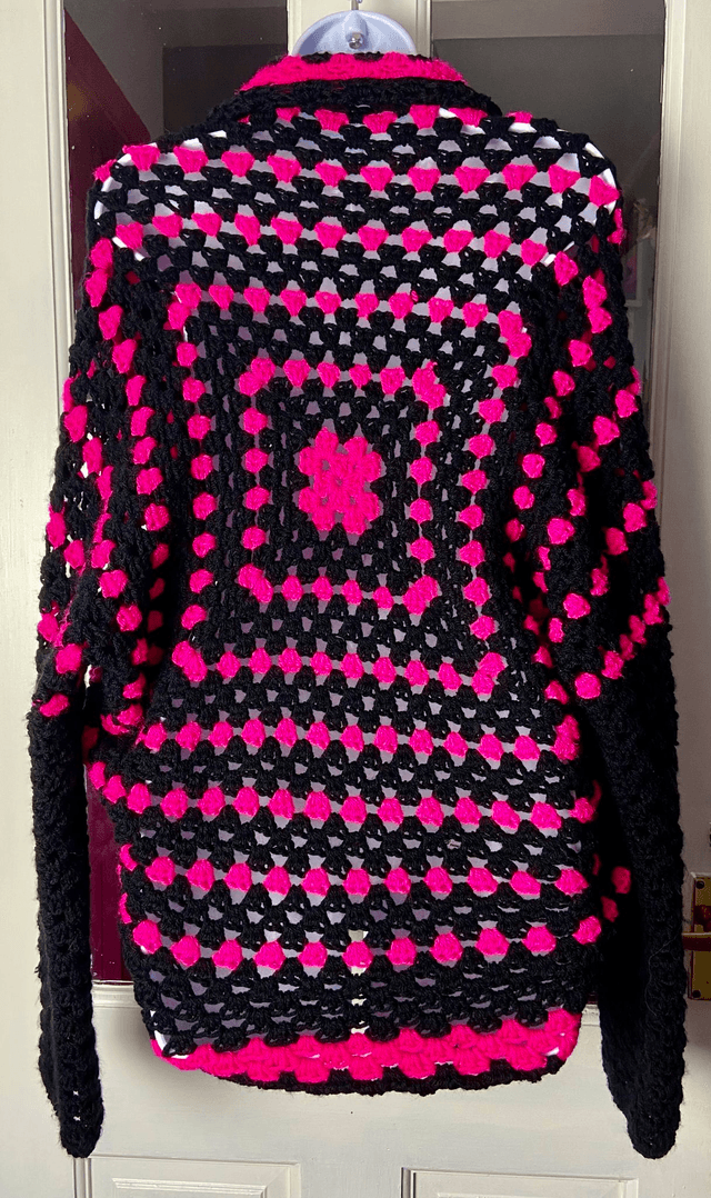 Pink and black shrug style cardigan.