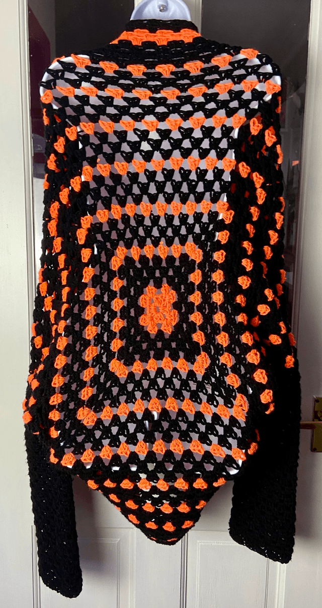 Orange and black shrug style cardigan.