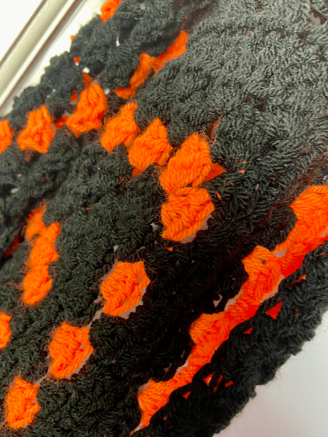 Orange and black shrug style cardigan.