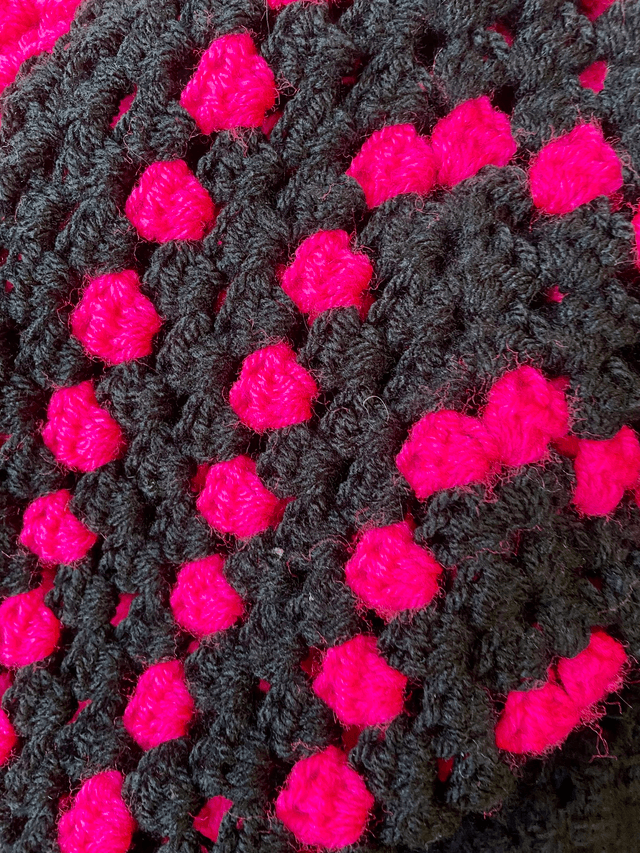 Pink and black shrug style cardigan.