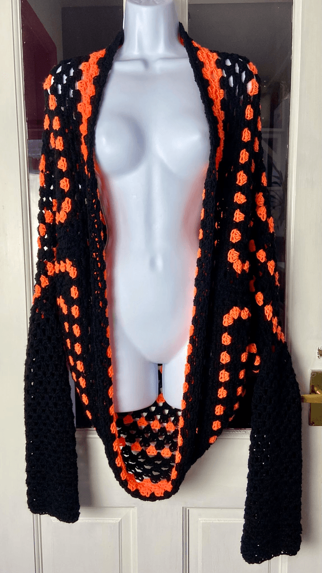 Orange and black shrug style cardigan.